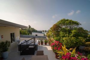 a balcony of a house with flowers and plants at Vilu Himmafushi in Himmafushi