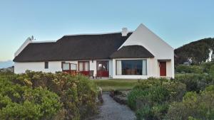 uma casa branca com um telhado preto em Draaihoek Lodge & Restaurant em Elands Bay