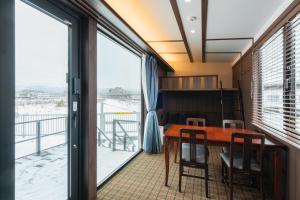 a dining room with a table and a large window at JR Mobile Inn Hakodate in Hakodate