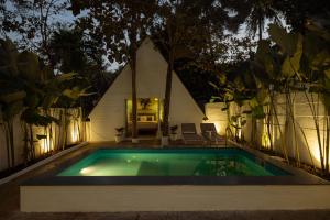 a swimming pool in front of a house at night at Jalvasa Villa's in Canacona