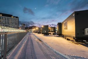 a row of train cars parked on a snowy street at JR Mobile Inn Hakodate in Hakodate