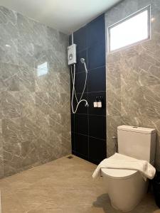a bathroom with a toilet and a window on the wall at เดย์ อิน in Ban Nong Sua Chang