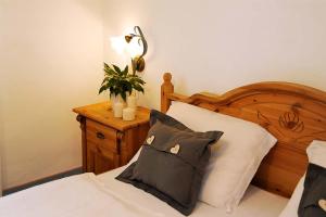 a bedroom with a bed with a black and white pillow at Residence Fischerhof in Tirolo +42 photos