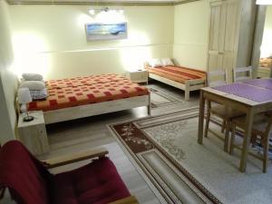 ザコパネにあるPokój gościnny w Zakopanemのベッド2台、テーブル、椅子が備わる客室です。
