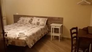 a bedroom with a bed and a table and a desk at Roma Fuori Porta in San Cesareo