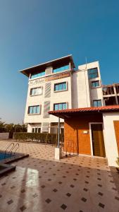 a large white building with a lot of windows at Hotel Ashoka Kokan Ganpatipule in Ganpatipule