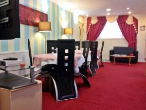 comedor con mesa y sillas en una alfombra roja en City View Hotel - Roman Road Market, en Londres