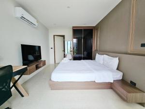 a bedroom with a large bed and a flat screen tv at patong see view condo in Patong Beach