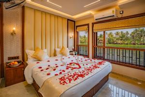 a bedroom with a large bed with roses on it at My Trip Houseboats in Alleppey +45 photos