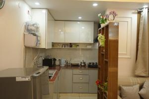 a small kitchen with white cabinets and a refrigerator at kailash keep in Haridwār