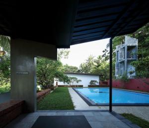an external view of a house with a swimming pool at Clover Bentota in Dedduwa