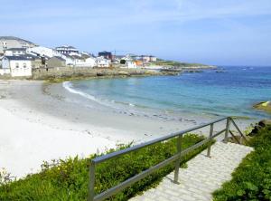 una escalera que conduce a una playa con el océano en San Ciprián Playa y Mar by I Love Norte, en San Ciprián