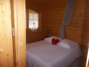 a bedroom with a bed with a red heart on it at Chalet flottant sur lac et spa in Mios