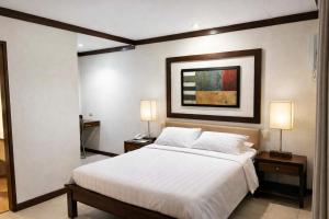 a bedroom with a large bed with two night stands at O Hotel in Bacolod