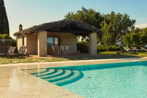 una casa con tetto di paglia e piscina di Villa Agazzi by PosarelliVillas a San Zeno