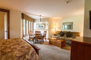 Sala de estar con cama, sofá y mesa en Winwood Inn & Condominiums, en Windham