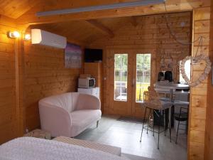 a living room with a white couch and a kitchen at Chalet flottant sur lac et spa in Mios