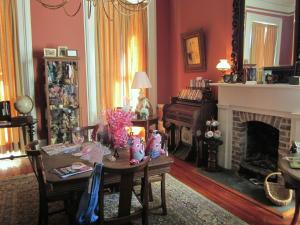 a living room with a table and a fireplace at Baer House Inn in Vicksburg