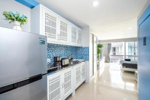 a kitchen with white cabinets and blue tiles at Hua Hin Condo B - Maysa & Hin Nam in Hua Hin