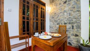 a dining room with a table with a plate of food on it at Sunrise Cottage in Sigiriya
