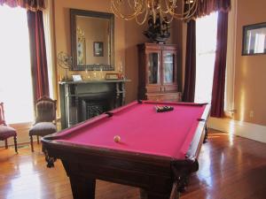 una mesa de billar roja en una habitación con chimenea en Baer House Inn en Vicksburg