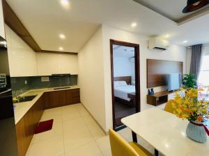 a kitchen with a table and a room with a bed at Mermaid Seaside Condotel in Vung Tau