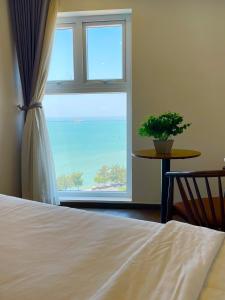 a bedroom with a bed and a large window at Mermaid Seaside Condotel in Vung Tau +17 photos