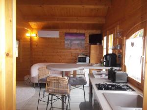 a kitchen with a table and chairs in a cabin at Chalet flottant sur lac et spa in Mios
