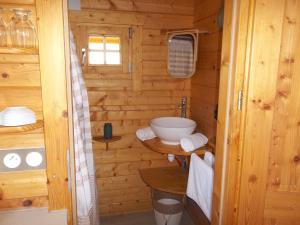 a bathroom with a sink in a wooden cabin at Chalet flottant sur lac et spa in Mios +13 photos