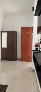 a room with two wooden doors and a white floor at Riyanhouse in Pūrnānkuppam +8 photos