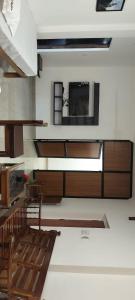 a living room with a couch and a television on the wall at Riyanhouse in Pūrnānkuppam