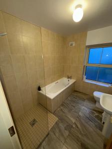 a bathroom with a tub and a toilet and a sink at 4 Bedroom House By Travel Lets Holiday Homes Downings With Beautiful Ocean View in Downings +30 photos