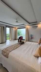 a large white bed in a room with a large window at Yoga bale house3 in Padangbai