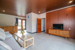 a living room with a couch and a flat screen tv at Arsyana Villa in Sidemen