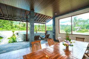 a dining room with a wooden table and chairs at Arsyana Villa in Sidemen