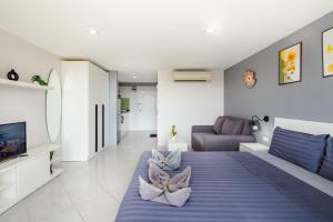 a living room with a blue bed and a couch at Hua Hin Condo C - Maysa & Hin Nam in Hua Hin