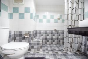 a bathroom with a toilet and a tiled floor at Hua Hin Condo C - Maysa & Hin Nam in Hua Hin