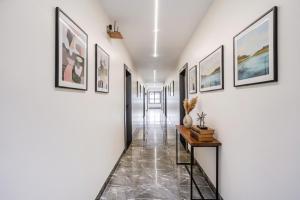 a hallway with framed art on the walls at FabHotel Ansh in Aurangabad