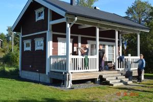 un uomo che scatta una foto di una piccola casa di Purolomat a Merikarvia