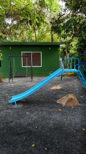 a blue slide in front of a green building at Bamboo Planet Resort in Vythiri