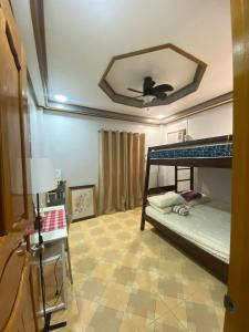 a bedroom with a bunk bed with a ceiling fan at Naybe's Room rentals in Dapa