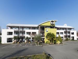 um parque de estacionamento vazio em frente a um hotel em B&B HOTEL Laval Changé em Changé