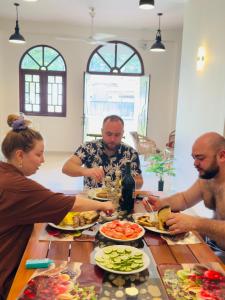 a group of people sitting around a table eating food at THC - Tropical Hideaway Ceylon in Talpe