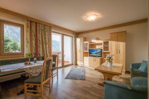 a living room with a table and chairs and a television at Appartements Rofan in Maurach