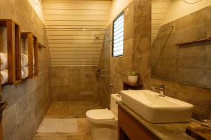 a bathroom with a sink and a toilet and a shower at Jalvasa Villa's in Canacona