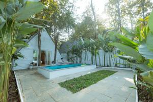 a backyard with a swimming pool next to a house at Jalvasa Villa's in Canacona +31 photos