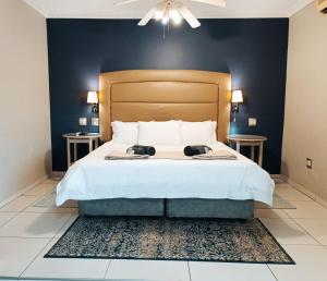 a bedroom with a large bed with two night stands at Pecan Farm Guesthouse in Louis Trichardt