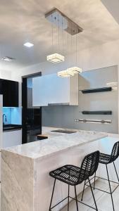 a kitchen with a marble counter and two chairs at 3BR family friendly Apartment at The Elements Ampang Kuala Lumpur in Kuala Lumpur