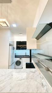 a white kitchen with a washing machine in it at 3BR family friendly Apartment at The Elements Ampang Kuala Lumpur in Kuala Lumpur