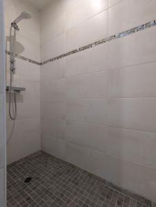 a bathroom with a shower with a tile floor at domaine de marodi jasmin in Baignes-Sainte-Radegonde